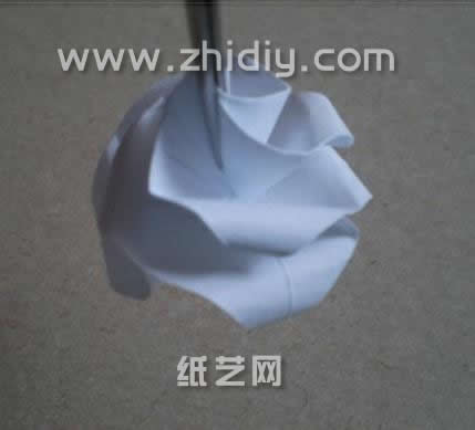 用镊子将手工折纸玫瑰的形状调整的更加好