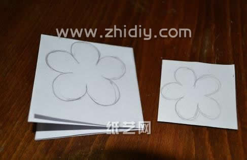 使用基本的白色纸张就可以制作这个圣诞贺卡用的剪贴花，和普通的手工纸艺花制作方法是相似的，都会使用到花纹模版