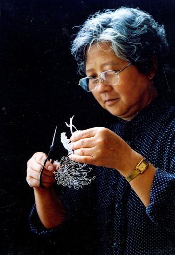 中国民间剪纸艺人张秀兰在认真的进行剪纸作品的创作