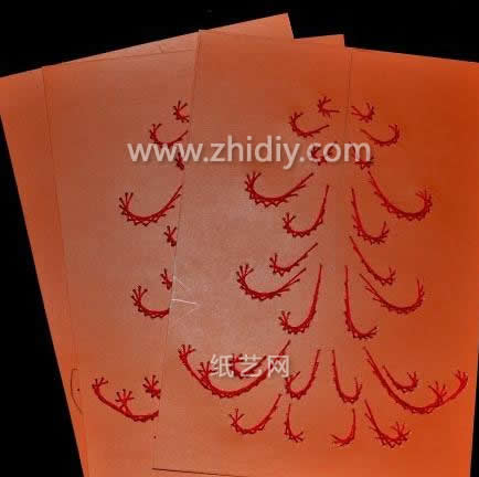 使用纸绣的方法将卡纸上面的圣诞树图案勾勒出来