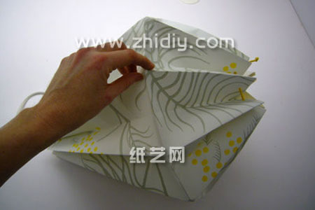 第五步是对这个手工纸艺折纸灯罩的另外折痕凸起的结构进行拉开、立体化的处理