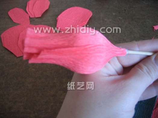 这个时候就可以将这个折纸玫瑰的花茎部分木签子插入到巧克力里面从而形成折纸玫瑰的花茎了