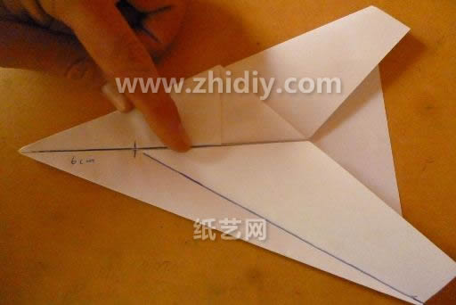 这个时候折纸飞机的机翼部分还需要用辅助折痕的方式将折痕压折出来
