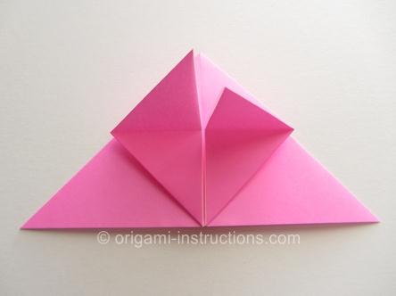 向下的拉折可以很好的利用其经过折叠之后形成的折痕从而使得三角形的纸张被压平展