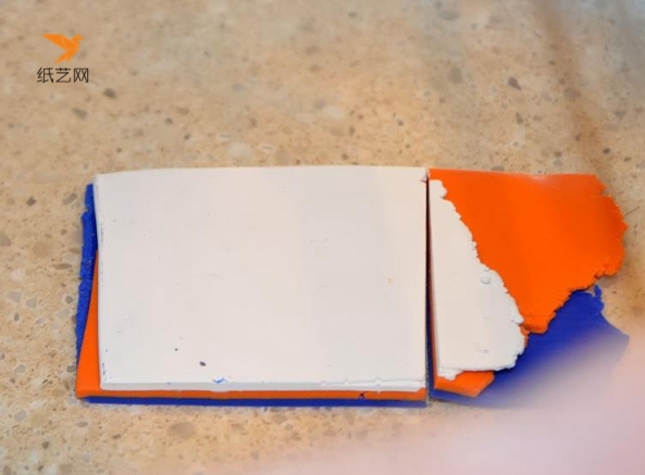 然后将蓝色，橘色和白色的超轻粘土分别擀成薄片之后，叠放在一起，裁掉多余部分