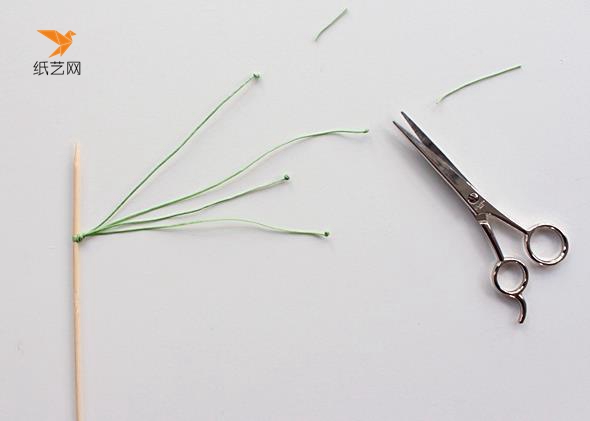 在竹签上系上绿色的棉绳，然后在末端打结，剪掉多余的部分作为花蕊