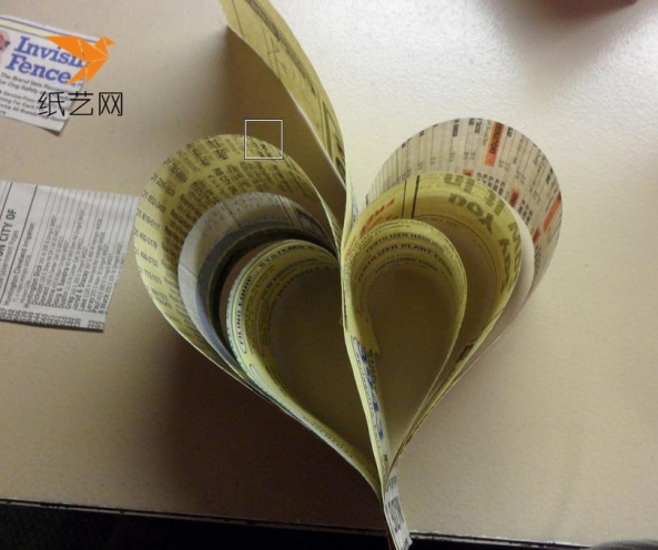 中间放上一个纸条，将上面一端粘在纸条上面，成为一个心形