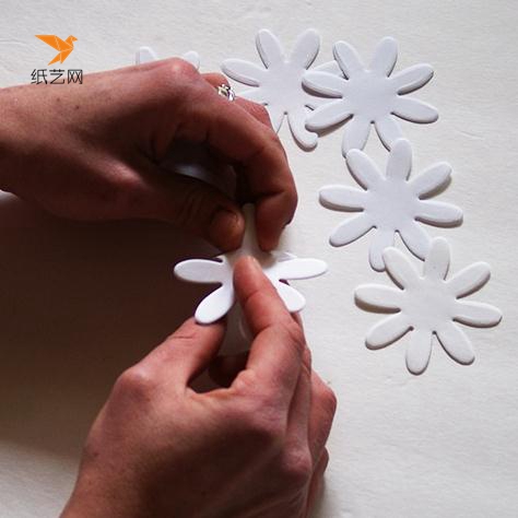 制作小雏菊纸艺花首先要先用白纸制作出一朵朵的花朵样，然后用手将花瓣捏成立体的样子