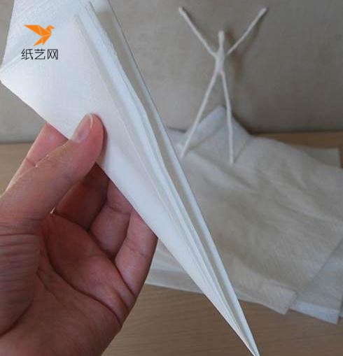 把一张完整的餐巾纸进行折叠，然后宽的一边用剪刀剪出弧形