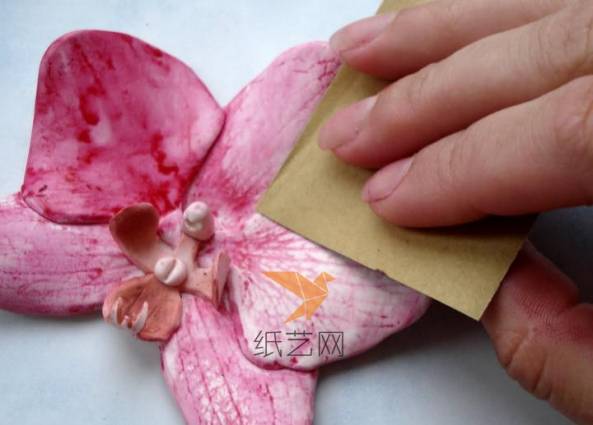 用细砂纸慢慢将表面的颜料打磨掉，注意不要把花瓣的纹理磨掉了