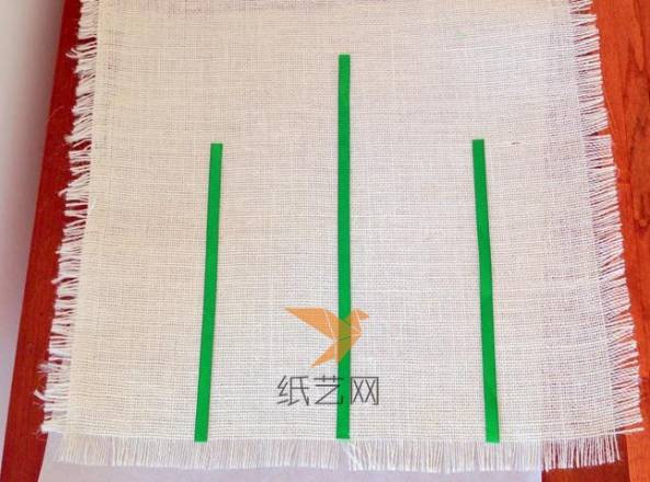 用绿色丝带粘贴到麻布上丝带花的位置作为花茎