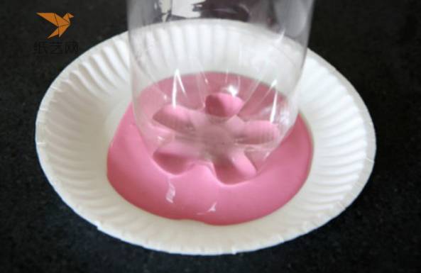 一次性蛋糕盘里放上粉色颜料，用洗干净的塑料瓶的底部沾取颜料