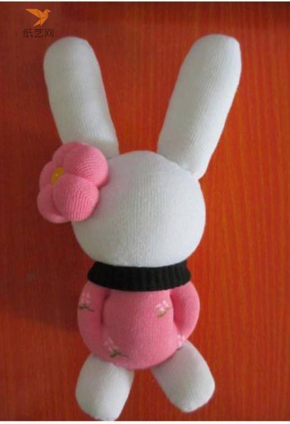 缝上小兔子的耳朵和两条腿，耳朵上装饰上玫红色花朵