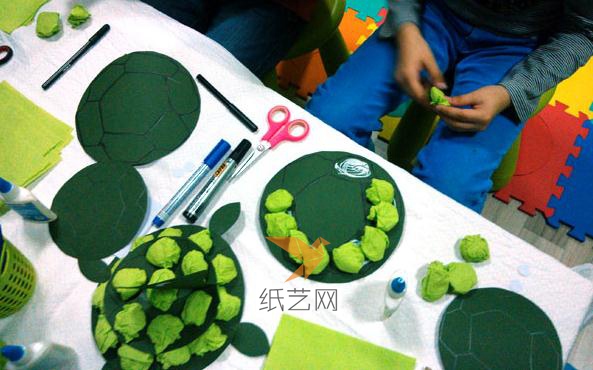 接着把薄薄的绿色纸张剪成小的方形，团成一团，用胶粘到乌龟壳上面就可以啦