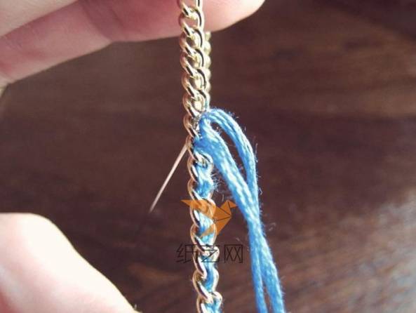 用彩色的线在金属链的孔上编织好