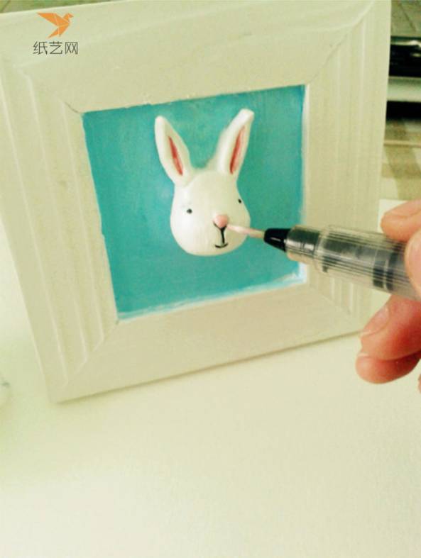 用笔画上兔子的眼睛、鼻子、嘴巴和耳朵内侧的轮廓