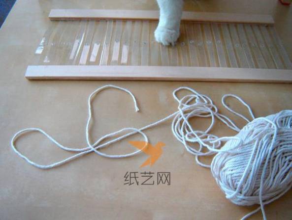 然后先把白色的毛线固定到编织机上面