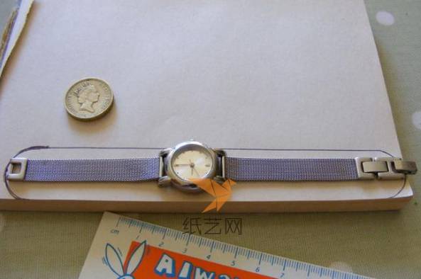 把手表先在纸张上面画出要制作的手表套的轮廓大小