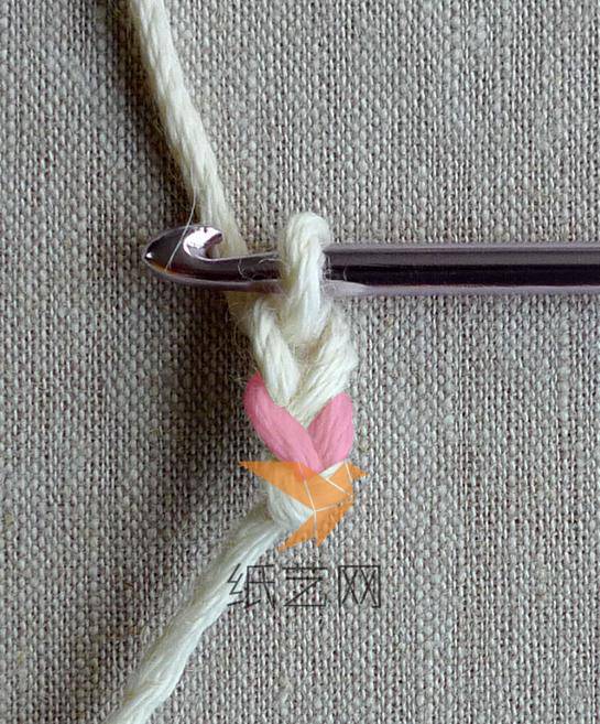 首先编织两个辫子针，然后下一步要穿过的是标记成粉色的两条线