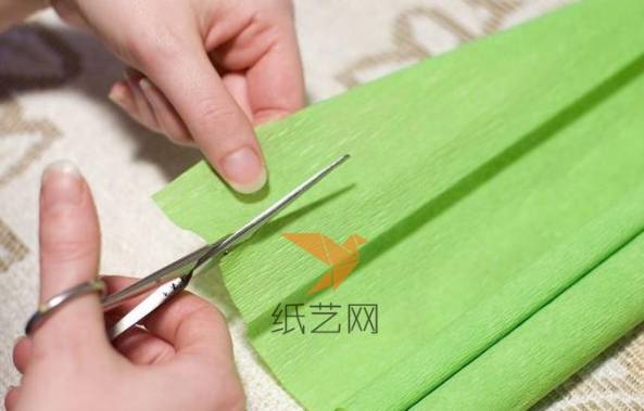 用剪刀剪下一块窄窄的绿色皱纹纸