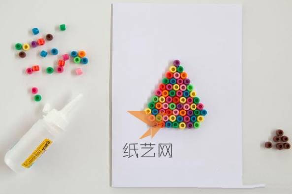 用白乳胶粘到贺卡纸上面，粘成一棵彩色的圣诞树的样子
