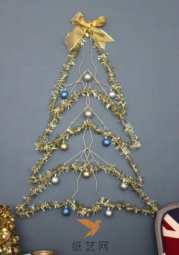 在衣架上面挂上挂饰，最上面用丝带制作的蝴蝶结来装饰，圣诞树就制作完成啦