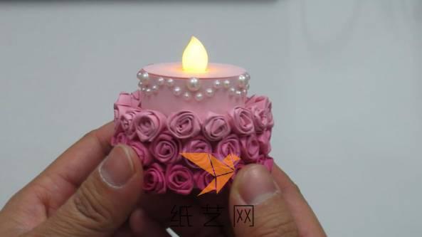 为了让烛台更加漂亮，在折纸玫瑰的上面粘上小珠子来装饰，这样的蜡烛在情人节的时候用非常的合适哟