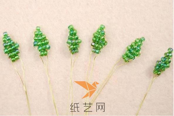 然后用绿色的珠子来制作玫瑰花的花萼