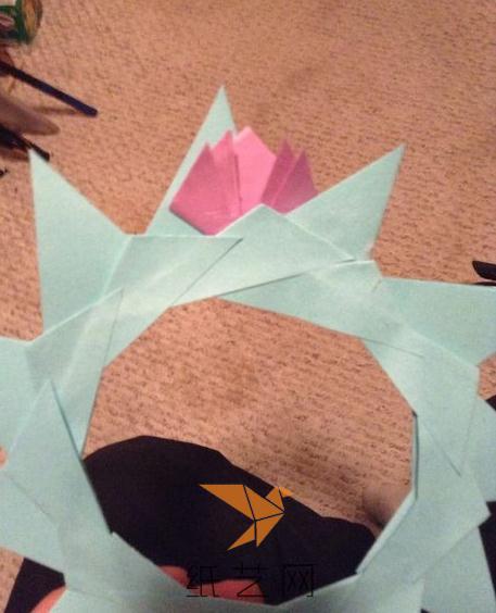 接着就可以把折叠的小花样子的纸张粘到前面制作的圆环上面了