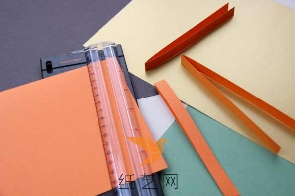 首先我们将彩纸对折，然后剪裁成同样宽度的细细的纸条