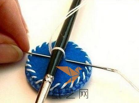 在背面用不织布圆片缝上，然后需要用小号的油画笔作为标准来缝好纽扣的环
