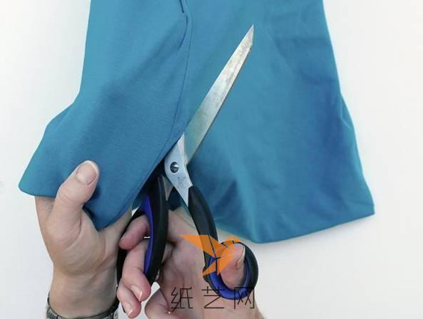 用剪刀从衣服的两侧剪开成为一大片的布