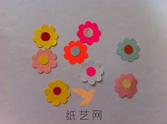 然后用彩色的彩纸制作这种小花朵，中间用其它颜色的彩纸剪成小圆片粘好，就做好花朵了