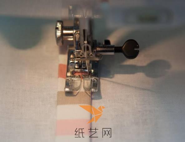 用缝纫机将布条的两边缝在上面，注意两端要留有开口，方便穿绳子