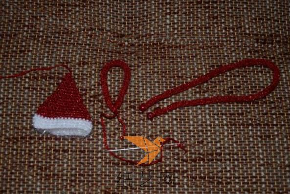 接着用彩色的毛线来编织一个小帽子，再编织两根绳子作为挂绳和脖子上面的围巾