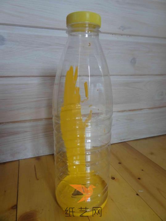 在饮料瓶里面倒入黄色的颜料