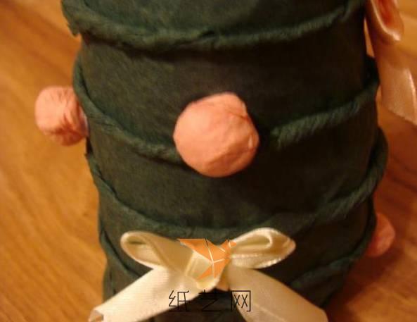 用粉色的彩纸团成小球站在上面，再用丝带做成蝴蝶结装饰一下