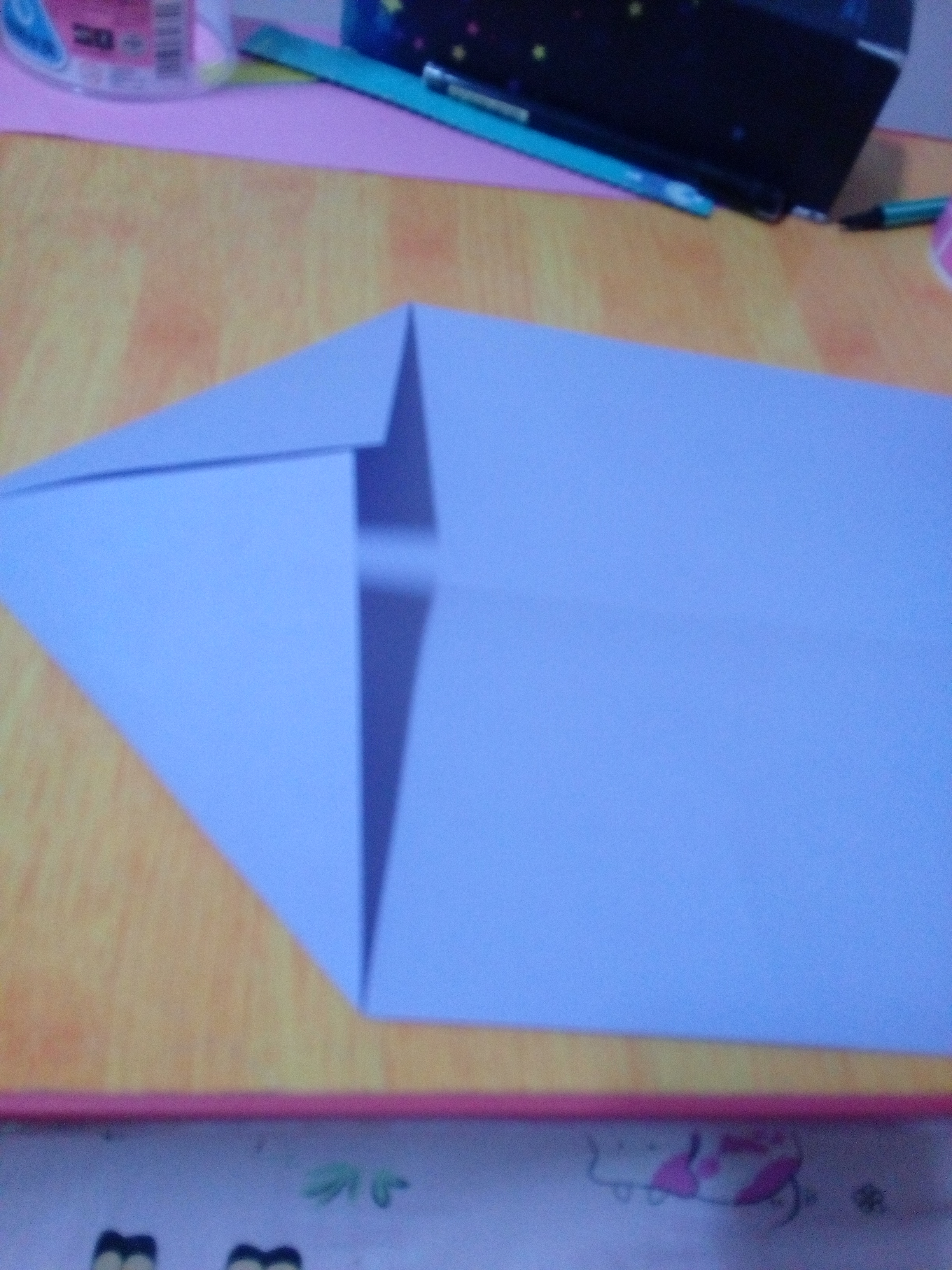 把纸按折痕折成一个三角