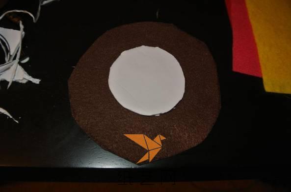 下面要用棕色的不织布将圆形纸板包起来，先剪好棕色的不织布