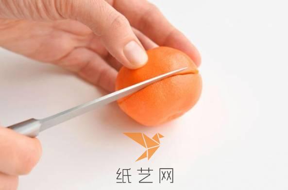 用水果刀将橘子中间的皮切开，尽量不要切到果肉