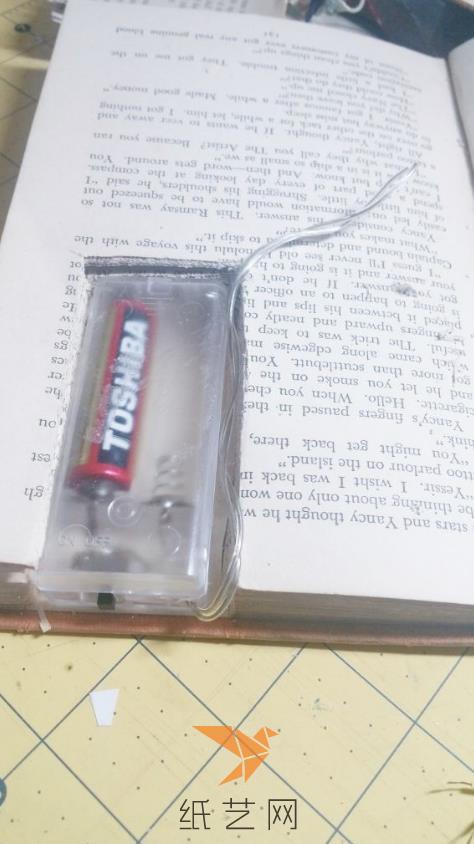 将电池要藏到书页里面，用美工刀剪好一个合适的槽放好