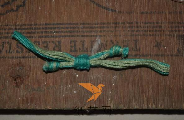 用毛线来制作好串珠手链中间的连接部分，中间是用编织好的一个扣来作为活动扣的