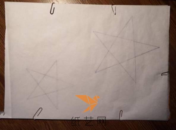 下面来将星星的样子画到白纸上面，铺上一层硫酸纸，然后用别针将边上固定起来