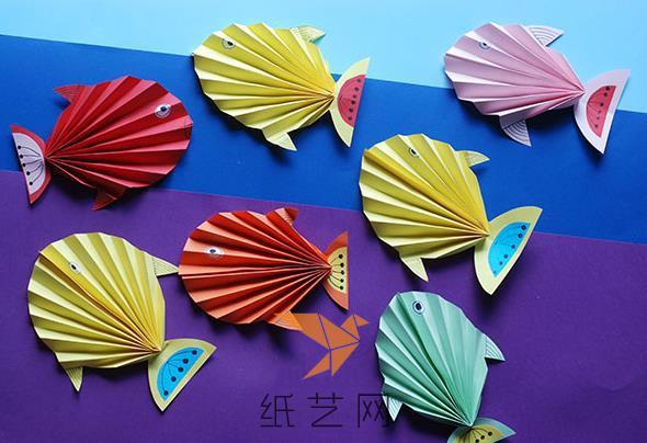 下面就可以将折纸热带鱼的眼睛和尾巴的装饰粘到上面了。接着小朋友们就可以用自己制作的各种颜色的折纸热带鱼来制作一副漂亮的粘贴画啦。