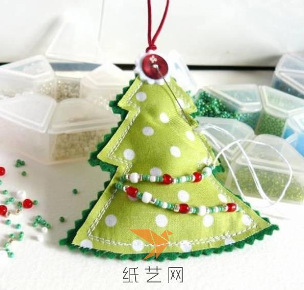 接着，我们就可以把这个布艺小圣诞树装饰一下子，用圣诞节主题色的珠子来装饰就在合适不过的了