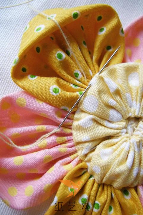 把这个圆形的部分缝到布艺花瓣的中间